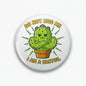 Round cactus pinback button with green cartoon cactus and 'DO NOT HUG ME'