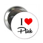 Round pinback badge with white face, black 'I' and 'Plick', red heart icon