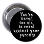 1.25-inch black pinback button with white slogan text; metal safety pin back