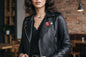 Round red pinback button on black leather jacket lapel