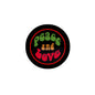 Round retro pinback badge with black edge, red ring, green peace and love text and heart icons