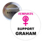 Round pinback button with feminist icon and text "Feminists Support Graham"