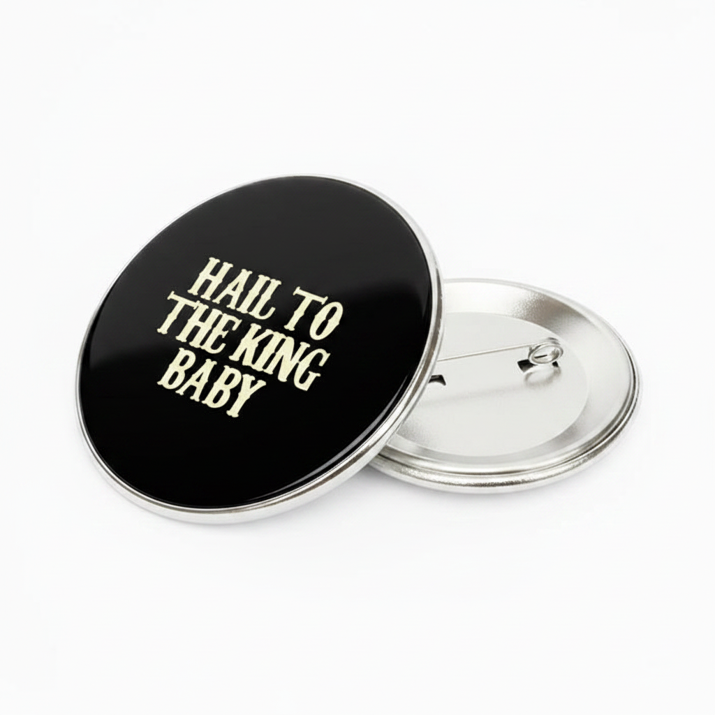2.25-inch black pinback button with gold “Hail to the King Baby” and metal clasp