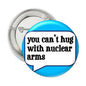 Round pinback button with blue speech bubble text: 'you can't hug with nuclear arms'.