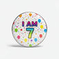 Age 7 birthday pinback with 'I AM 7' text, balloons and confetti
