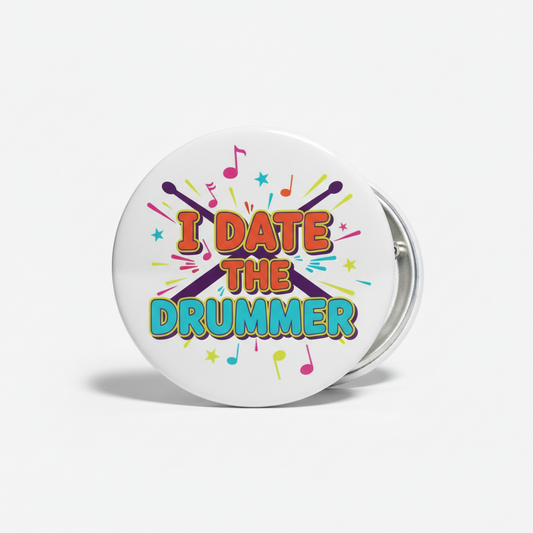 Button badge with 'I DATE THE DRUMMER' text and musical notes on a white background