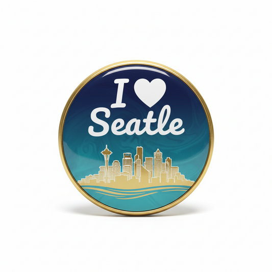 Round gold-framed pinback button with blue 'I ♥ Seattle' design