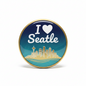 Round gold-framed pinback button with blue 'I ♥ Seattle' design