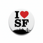 Round pinback button: white face, black "I SF" text, red heart, skyline and bridge