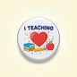 Round teaching pinback button: “I TEACHING” with red heart, apple, books