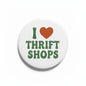 Round white pinback button with green “THRIFT SHOPS” text and a heart