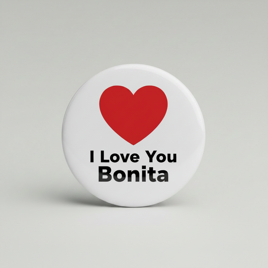 A round pin-back button badge with a silver metal rim, featuring a red heart icon above the black text 'I Love You Bonita' on a white background, set against a neutral gray studio backdrop.