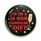 Black pinback button with gold rim, text '24 HOUR CHAMPAGNE DIET' and champagne glass