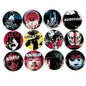 Twelve circular button badges featuring horror movie and cult film imagery, arranged in a 3x4 grid on a bright green background. Designs include Freddy Krueger, Ringw, Audition, Pulse, Ugetsu, Ase, One Footed, Ichi-Killer, One Missed Call, and Ju-On.