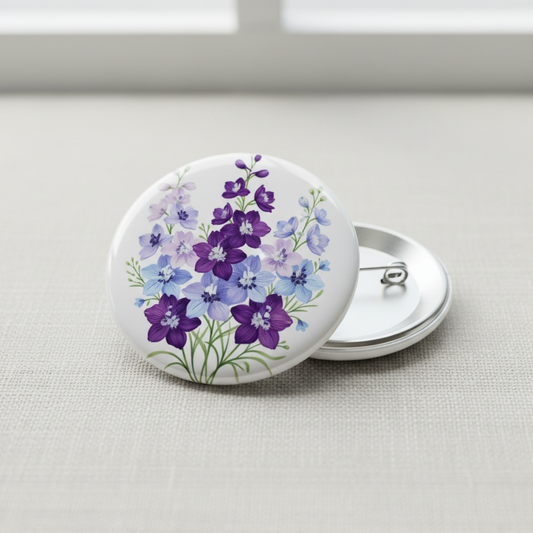 July birthday flower pinback button, round white enamel with purple and blue blooms, safety pin back
