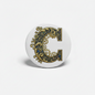 Round retractable badge reel with ornate gold letter C emblem
