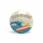 Round pinback button with 'Love to Surf' text, waves and surfboard graphic