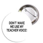 Round pinback button with black 'DON'T MAKE ME USE MY TEACHER VOICE!' text