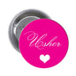 Round pink Usher wedding pinback with cursive “Usher” text and small heart