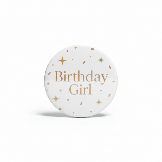 Birthday Girl pinback button, round white with gold text and star confetti accents