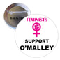 Circular enamel pinback button with Feminists Support O’Malley text and female symbol