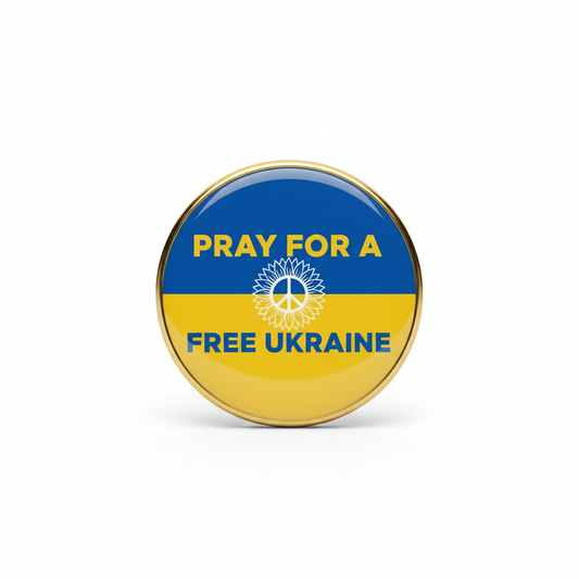 Round enamel-style pin with gold rim, blue and yellow design reading “PRAY FOR A FREE UKRAINE”
