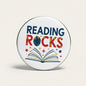 Reading Rocks 2.25-inch pinback button: circular metal with “READING ROCKS” and book graphic