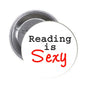 Round pinback button with white face text “Reading is” and red “Sexy”