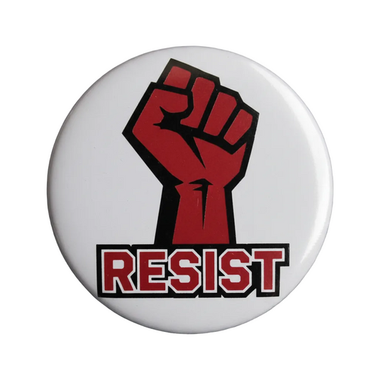 Button with red fist and 'RESIST' text on a denim background