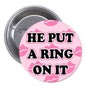 1.25-inch pinback button with pink camouflage and "HE PUT A RING ON IT" text
