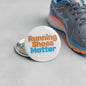 Round white pinback button with "Running Shoes Matter" lettering and metal pin