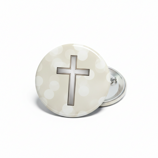 Round memorial pinback with silver border, beige dotted background and raised cross.