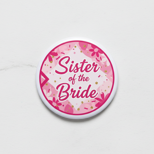 Pink round pinback badge with 'Sister of the Bride' lettering and confetti pattern