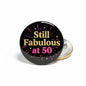 2.25-inch pinback button, black with “Still Fabulous at 50” text