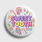 2.25-inch pinback button with colorful candy graphics and 'Sweet Tooth' text