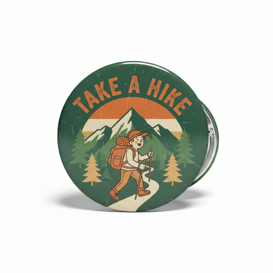 2.25-inch Take a Hike pinback button with hiker cartoon, trees and mountain graphic