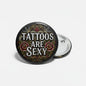 Round black pinback button with roses and the text 'Tattoos are sexy'