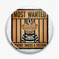 Inmate cartoon pinback button with smiley prisoner, jail bars, 'MOST WANTED' and 'REWARD' text