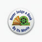 Round pinback button with colorful book and film icon and blue slogan text