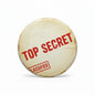 Cream round pinback button with red “TOP SECRET” and “CLASSIFIED” text