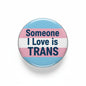 Round transgender pride pin with flag stripes and text "Someone I Love is TRANS"