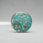 Round retractable badge reel with blue almond blossom artwork and metal edge