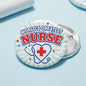 Round Worlds Greatest Nurse pinback button with stethoscope, red cross, and blue stars