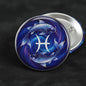 Pisces pinback button with blue fish zodiac artwork, round silver rim