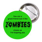 2.25-inch pinback button with green zombie text and safety-pin back visible