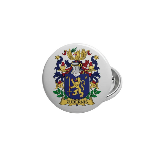 A round white button pin featuring a colorful heraldic coat of arms with a gold lion, blue shield, and the name 'ZUBERNIS' on a banner, photographed on a light gray textured surface.